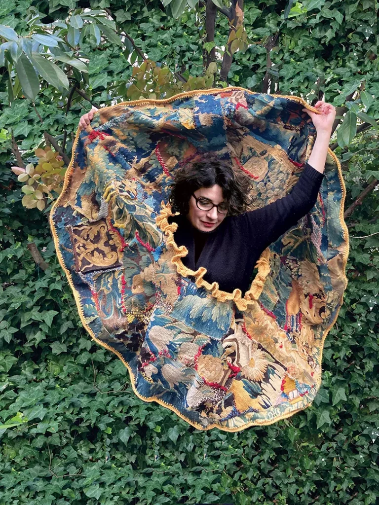 Moon, Tal Waldman, 2026.
Dimensions : 140 cm de diamètre. L’œuvre composée de fragments de tapisseries d’Aubusson des XVIIIe et XIXe siècles préserve une mémoire à la fois patinée par le temps et réparée, et elle possède une complexité symbolique et mémorielle unique. Des cicatrices brodées de laine soulignent les réparations. Elles révèlent la beauté de l’imparfait et du réparé, à l’instar du kintsugi – l’art japonais de réparer les objets cassés en mettant en valeur leurs fêlures déjà exploré dans ses œuvres antérieures. Née d’une exploration de l’identité centrée sur le cercle jaune imposé aux Juifs au Moyen Âge dont la forme est conservée, l’œuvre s’affranchit de cette symbolique pour l’ouvrir vers un disque ensoleillé : une lune ? Un portail ? Ou un orifice ? Symbole simple, comme une ouverture possible vers la vie, et peut-être au-delà.