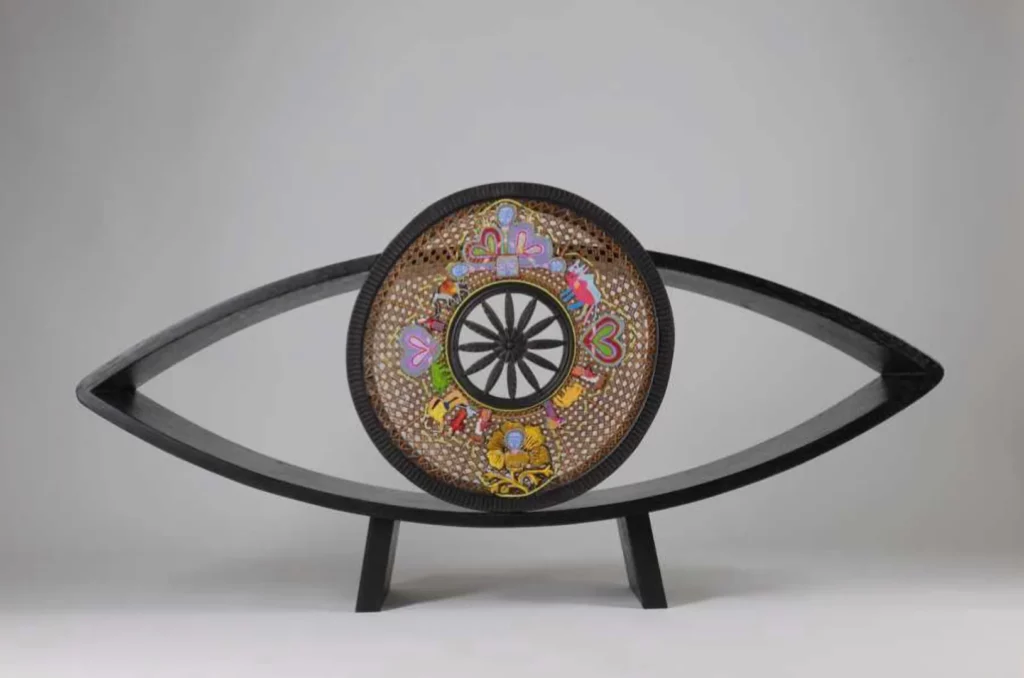 Entre deux terres, (Tal Waldman, 2015), Crédit photo : Alain Prince, Musée d’Art et l’Industrie La PiscineResearch Embroidered Memories, Entre deux terres, (Tal Waldman, 2015), broderie sur dossier recyclé, bois et peinture. 57 x 115 x 25 cm.
Mémoires brodées est un projet interdisciplinaire et collaboratif axé sur la mémoire collective, la migration et la diversité culturelle en tant que sources de renouveau et d’invention visuelle au sein d’un contexte historique et politique complexe. L’œuvre établit un lien entre la migration et le travail féminin précaire, tout en le reliant à une richesse culturelle acquise.
Publié dans La Voie d’Éxperimentation aux Éditions Lord Byron Cité du Vitrail (2024), Troyes, et dans le catalogue du Musée d’Art et d’Industrie La Piscine, Roubaix (2016)
